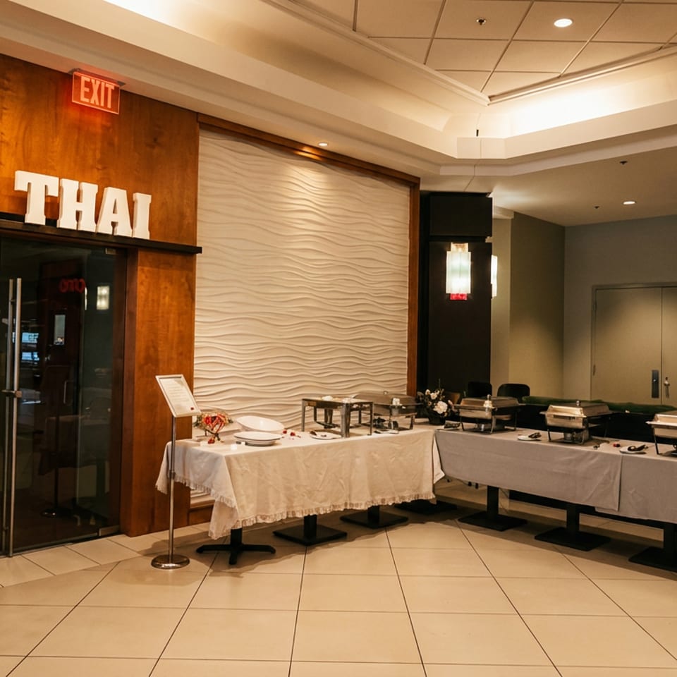 Nan Thai restaurant entrance with wood paneling, textured walls, and buffet tables set with covered chafing dishes.
